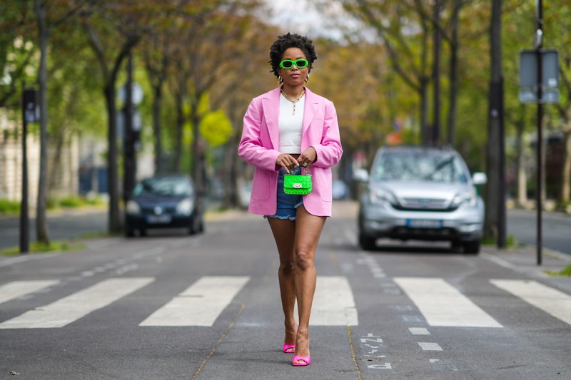 PARIS, FRANCE - MAY 02: Ellie Delphine wears neon green Versace sunglasses, gold earrings, a gold ch...