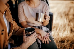 Midsection of couple holding hands and drinking coffee. Here's how to soft launch your relationship ...