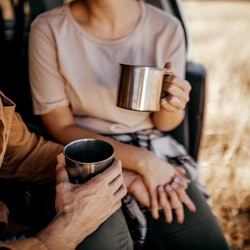 Midsection of couple holding hands and drinking coffee. Here's how to soft launch your relationship ...