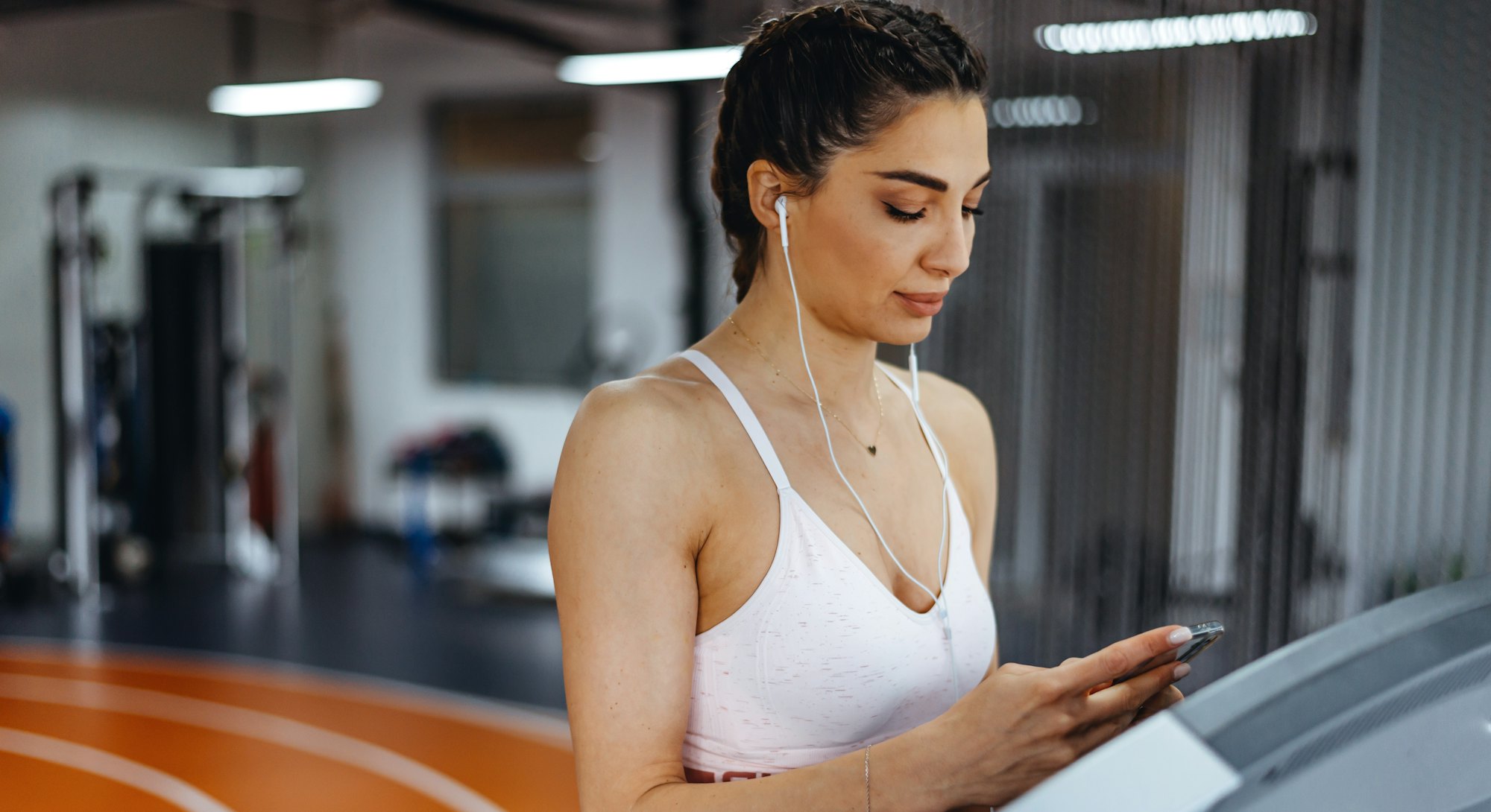 Young focused female working out at gym jogging on a treadmill. What are the benefits of tabata?