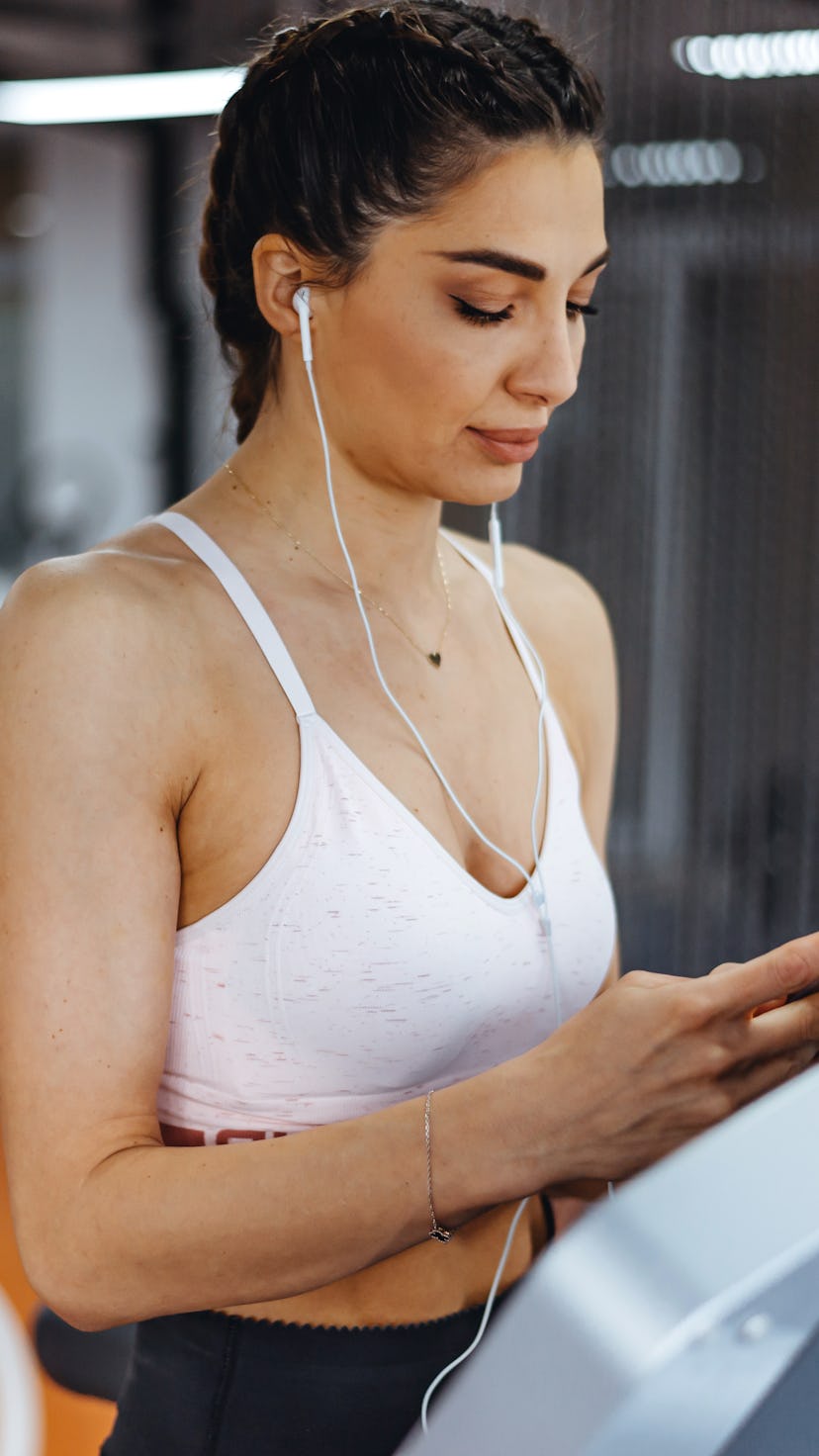 Young focused female working out at gym jogging on a treadmill. What are the benefits of tabata?