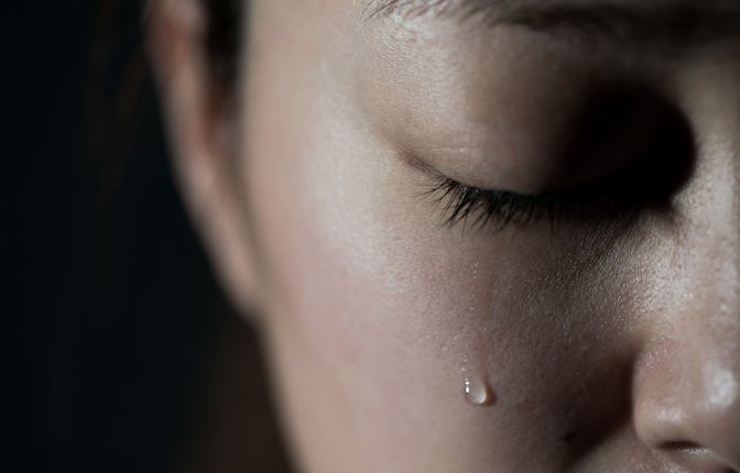 Young woman crying with tear drop.