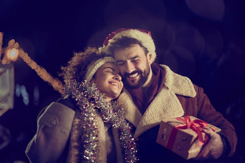 Happy couple in love enjoying during Christmas Eve on the street.