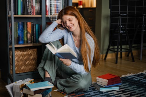 Young woman at home, reading a book