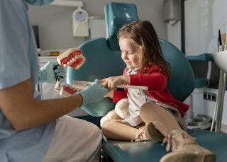 A small girl gets a lesson on brushing at the dentist -- while bacteria that leads to decay can be s...