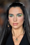 Dua Lipa walks the runway wearing neon eyeliner during the Versace Ready to Wear Spring/Summer 2022 ...