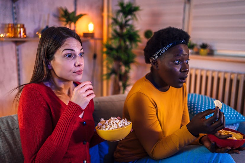 Women eat movie snacks with shocked expressions on their faces. Netflix announced a plan to crack do...