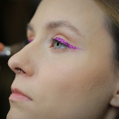 A model wearing glitter eyeshadow prepares backstage at the Nihan Peker show during Fashion Week Ist...