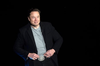 Elon Musk shows his Texas belt buckle as he speaks during a press conference at SpaceX's Starbase fa...