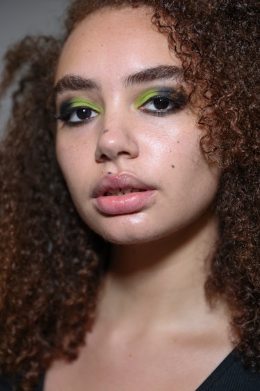  A model is seen backstage wearing neon eyeliner ahead of the Mark Fast show during London Fashion W...