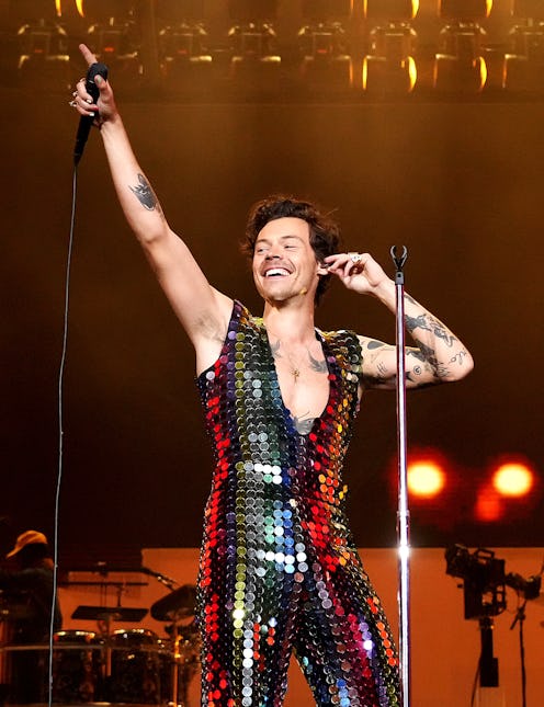 Harry Styles performs onstage at the Coachella Stage 2022 wearing a rainbow sequin jumpsuit