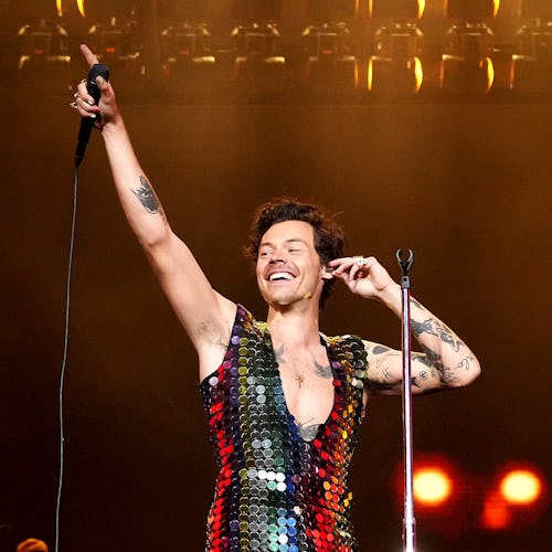 Harry Styles performs onstage at the Coachella Stage 2022 wearing a rainbow sequin jumpsuit