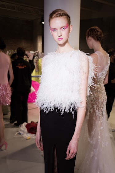 A model wearing neon eyeliner prepares backstage prior to the Celia Kritharioti Haute Couture Spring...