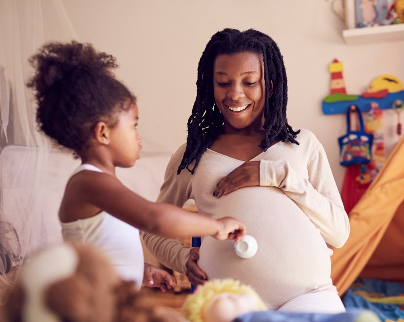 Being a mom isn't easy quotes; toddler daughter with teacup feeding happy pregnant mom