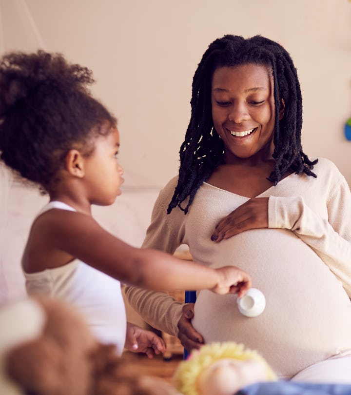 Being a mom isn't easy quotes; toddler daughter with teacup feeding happy pregnant mom