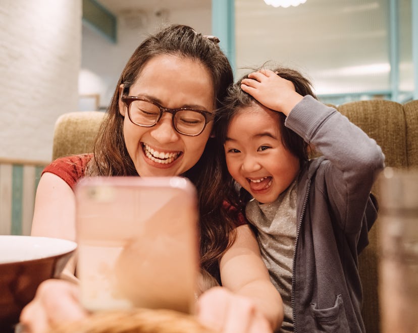 mom looking at mother's day ecard on her phone with daughter