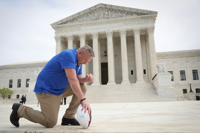 Former Bremerton High School assistant football coach Joe Kennedy takes a knee in front of the U.S. ...