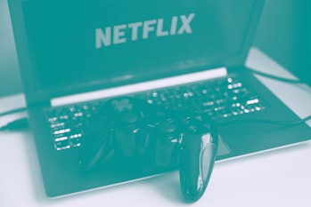 Netflix logo displayed on a laptop screen and a gamepad are seen in this illustration photo taken in...