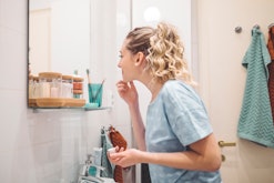 woman examining face in mirror, what to know about niacinamide during pregnancy