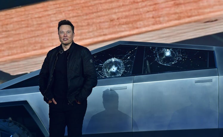 Tesla co-founder and CEO Elon Musk stands in front of the shattered windows of the newly unveiled al...