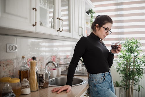 A young woman is drinking her morning coffee in her kitchen. Here's your april 28 zodiac sign daily ...