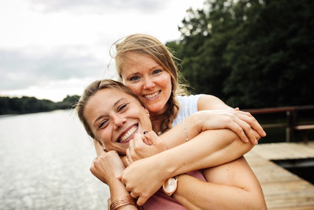 Happy blondhaired girlfriends enjoying time together, hugging each other.