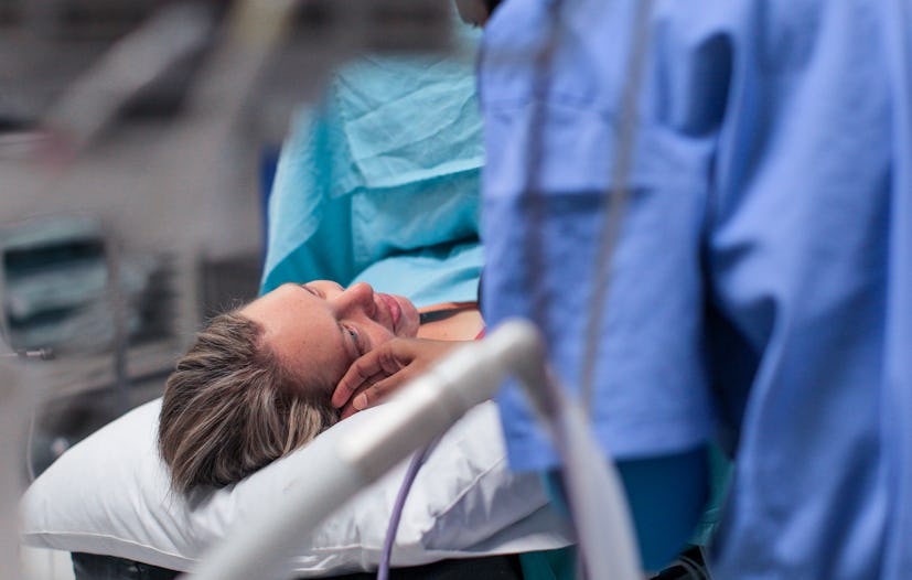 a Young pregnant woman lays on the operating table moments before a planned C-section