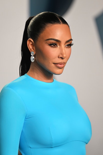 Kim Kardashian attends the 2022 Vanity Fair Oscar Party in a turquoise gown and diamond chandelier e...