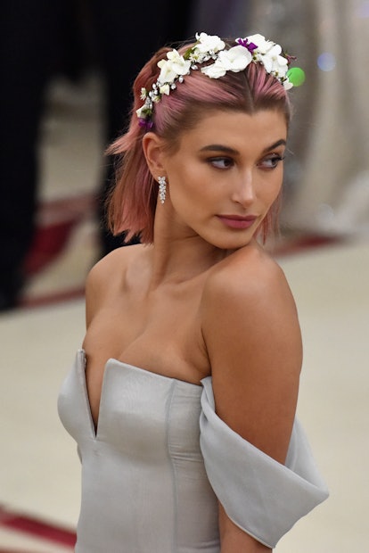 Hailey Bieber's best Met Gala hairstyles, including a pink bob haircut, beachy waves, and a barbie p...