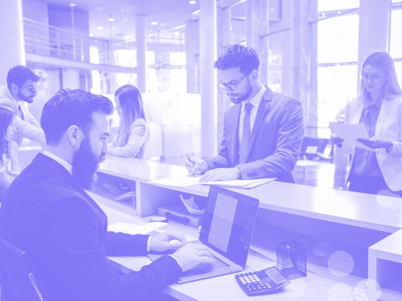 View of young businesspeople in a bank. They're waiting in line in order to talk to their advisors a...