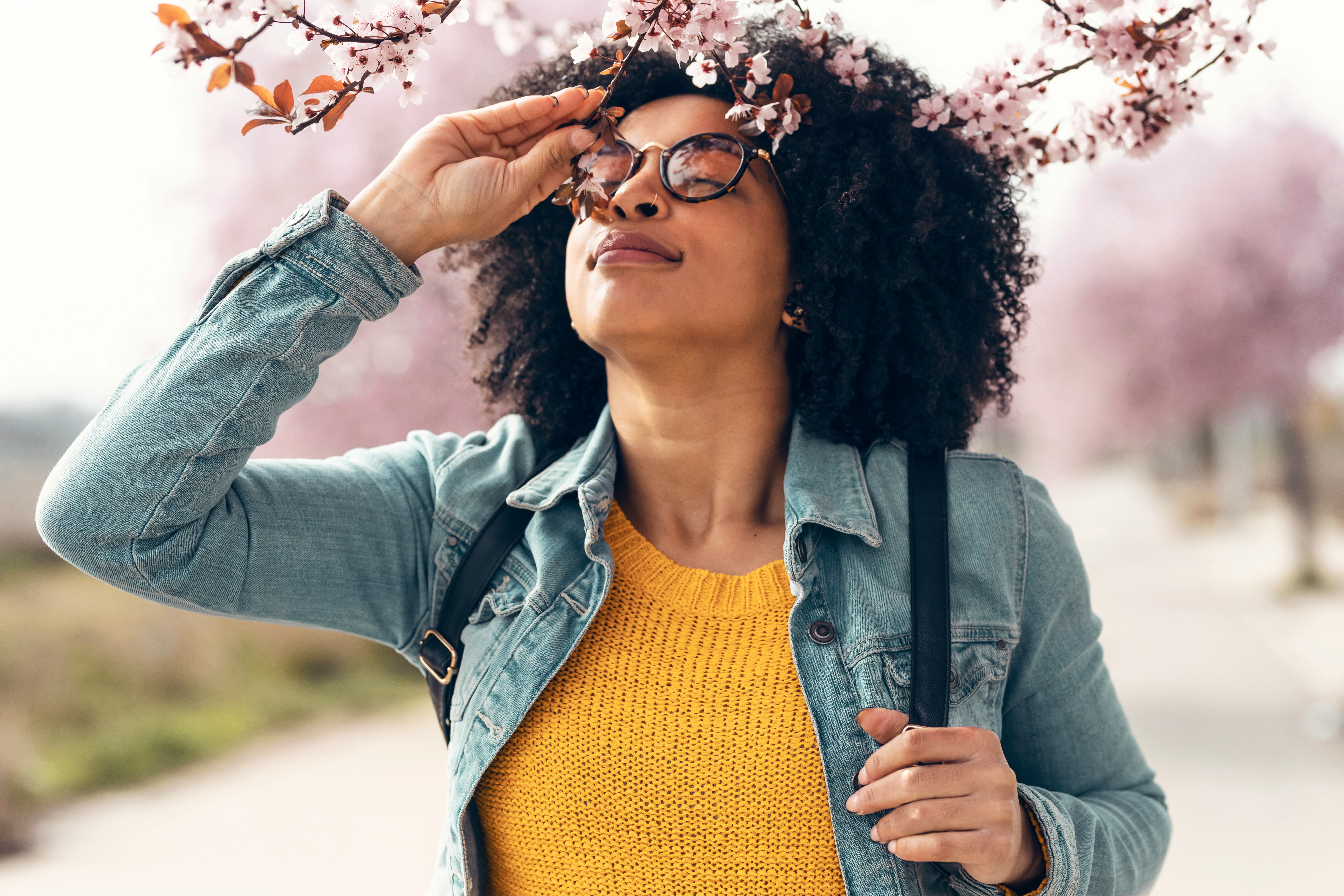 A woman smells cherry blossoms. This is your zodiac sign's luckiest day in may.