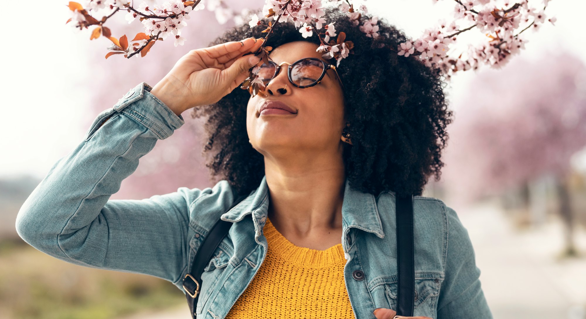 A woman smells cherry blossoms. This is your zodiac sign's luckiest day in may.