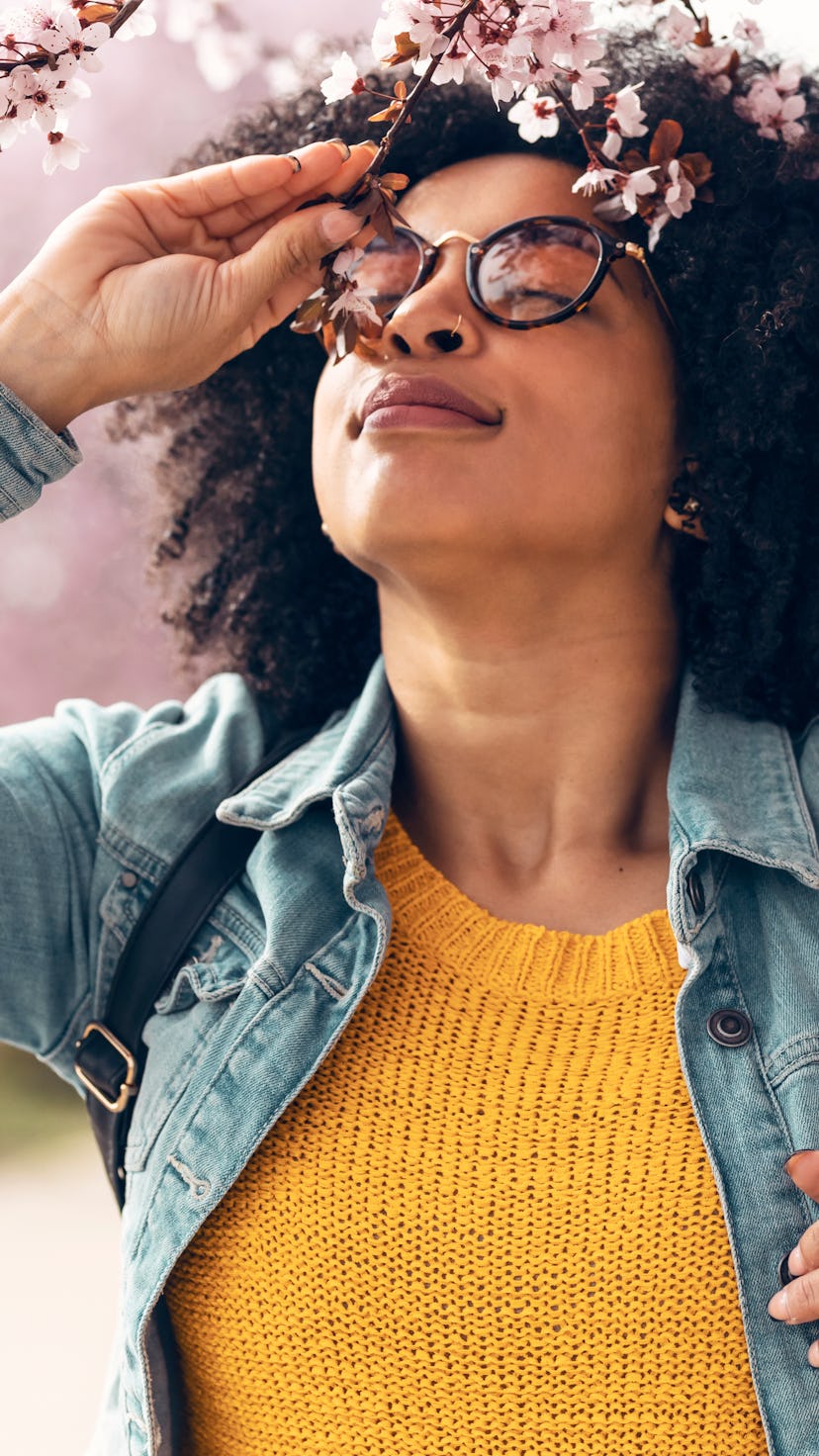 A woman smells cherry blossoms. This is your zodiac sign's luckiest day in may.