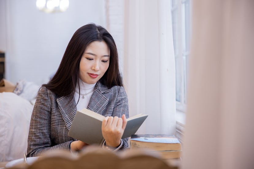 Young asian women reading a book by window