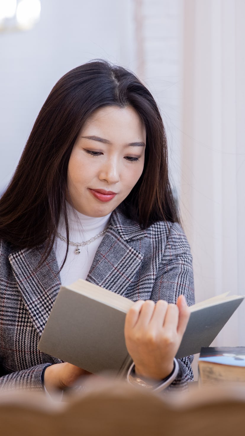 Young asian women reading a book by window
