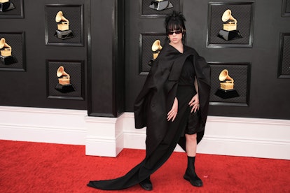 Billie Eilish wears a black asymmetrical dress with flatform shoes on the Grammys 2022 red carpet.
