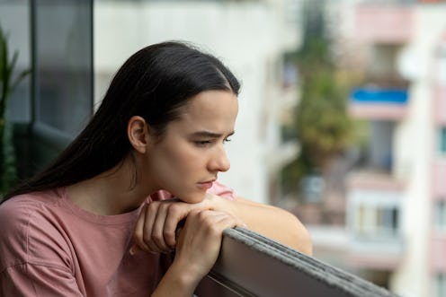 Woman staying at the balcony feeling worried
