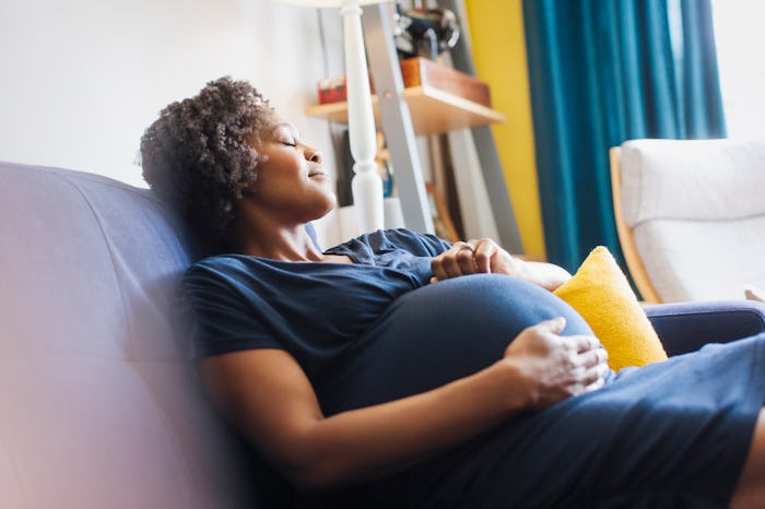 Serene pregnant woman napping on sofa