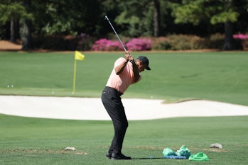AUGUSTA, GEORGIA - APRIL 03: Tiger Woods of the United States warms up in the practice area prior to...