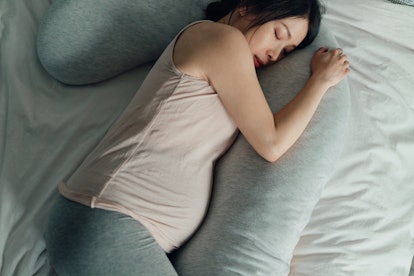 Elevated view of Asian Pregnant woman resting in bed. Comfortable sleeping positions during pregnanc...