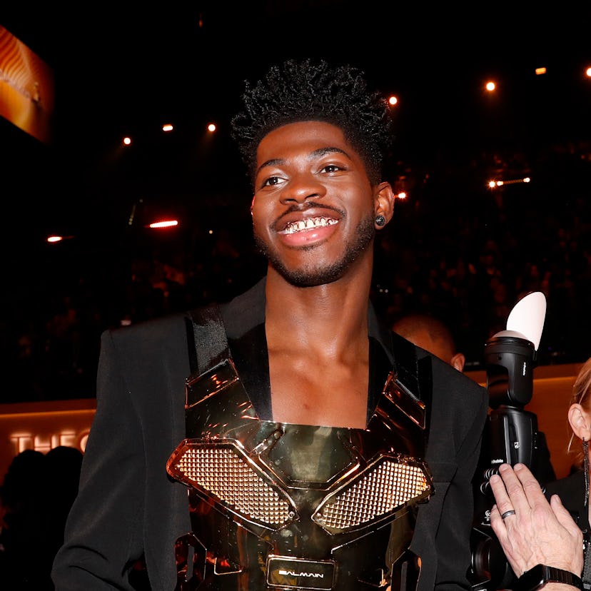 Lil Nas X wears a gold detailed jacket at the 2022 Grammys.