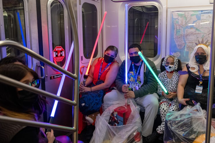 Cosplayers in costumes with lightsabers on a subway at the 34th Street station in New York