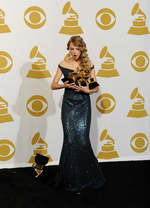 LOS ANGELES, CA - JANUARY 31:  Singer Taylor Swift drops a Grammy award while pose with Album Of The...