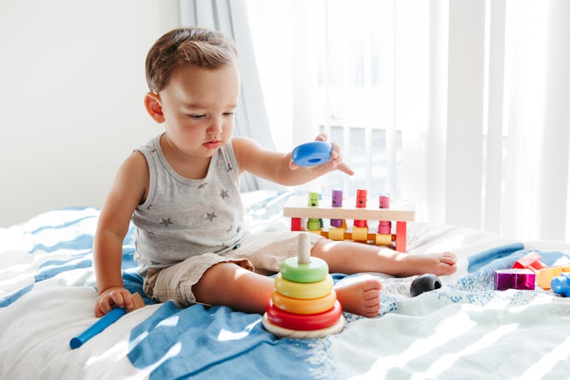 Montessori toys for 1-year-olds, toddler playing with wooden stacking toy