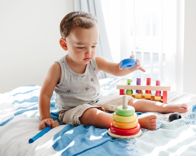 Montessori toys for 1-year-olds, toddler playing with wooden stacking toy