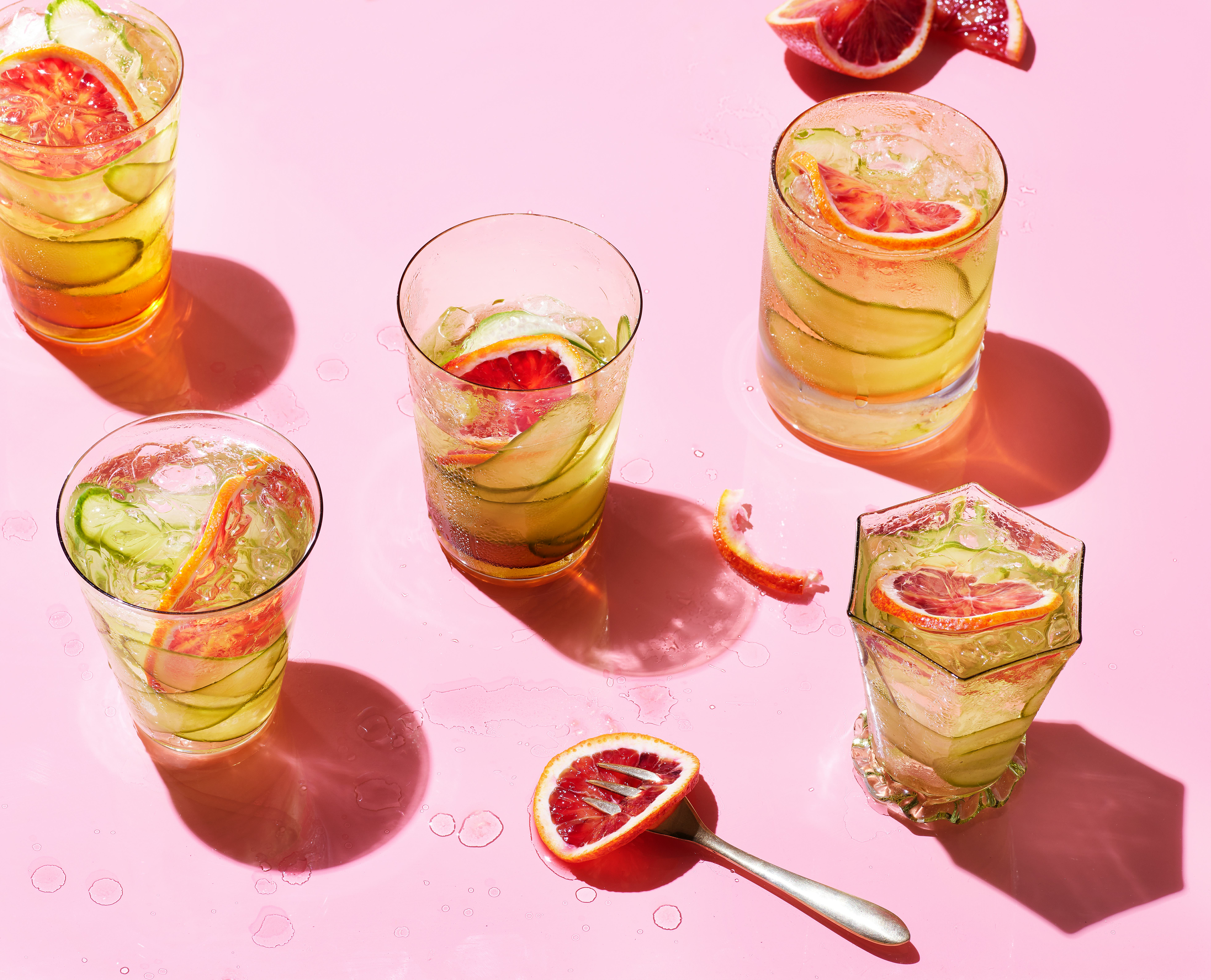 grid of cocktails on pink background with fruit and magazine