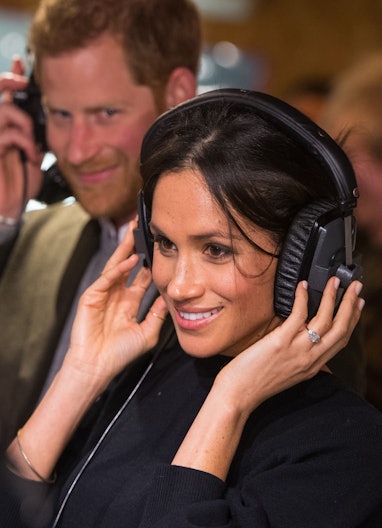 LONDON, ENGLAND - JANUARY 09: Prince Harry and Meghan Markle listen to a broadcast through headphone...
