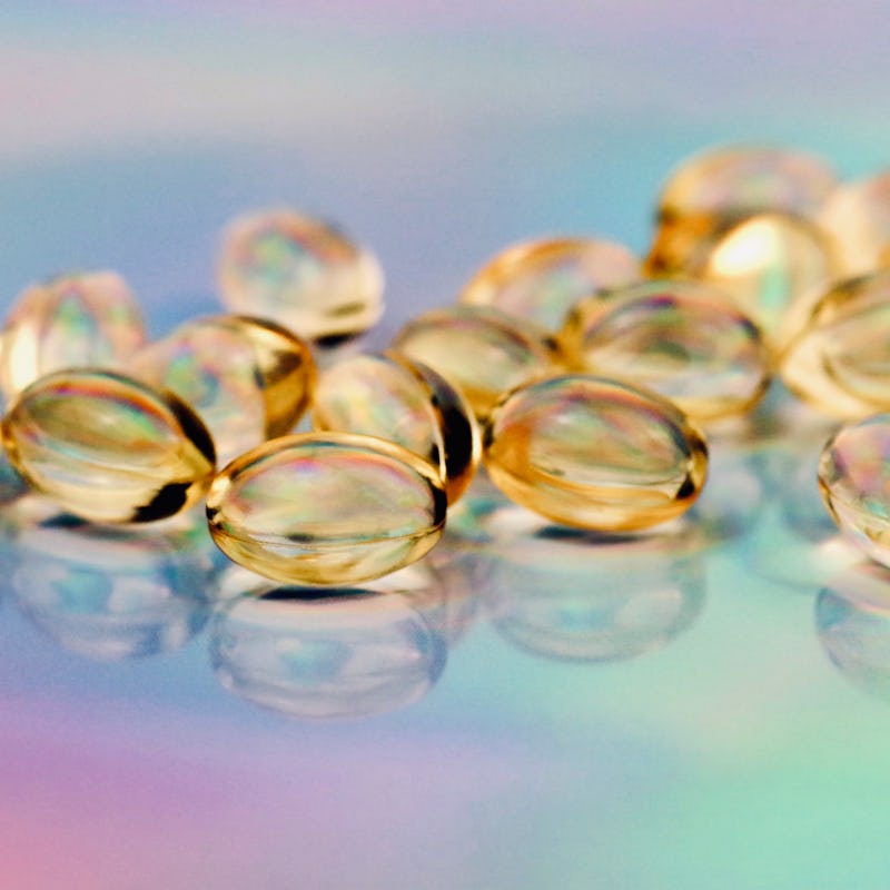 Macrophotography of gel cap pills on a holographic foil background