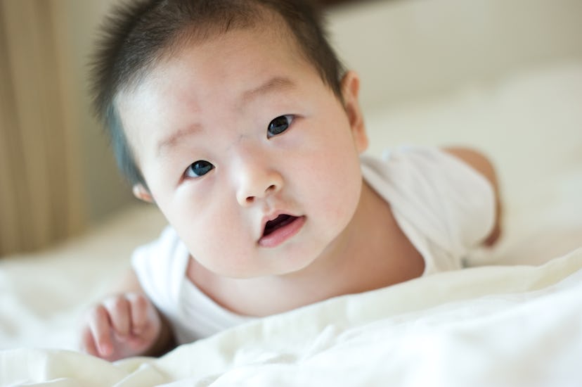 baby boy lying down in bed.