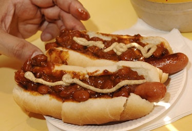 New York, UNITED STATES:  A customer with two hot dogs with chili and mustard is shown at the Papaya...